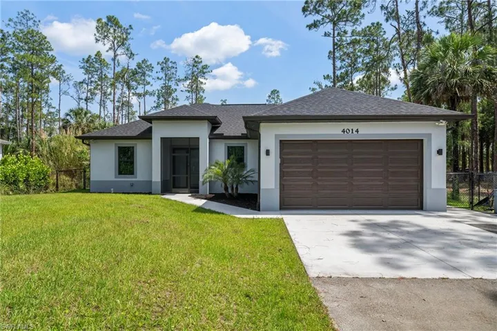 View of front of house with stucco siding, a garage, driveway, and roof with shingles