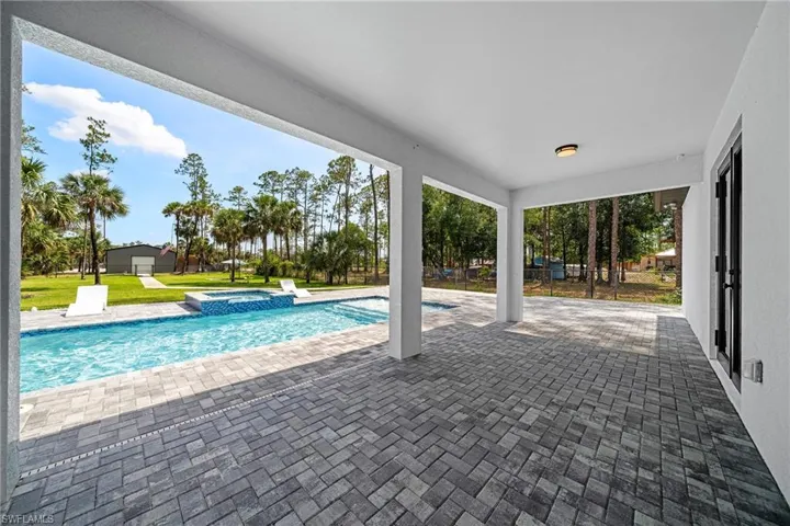 View of swimming pool featuring a patio and a pool with connected hot tub
