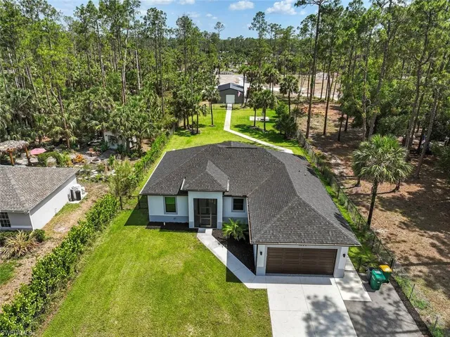 View of front of home featuring a garage, a shingled roof, concrete driveway, and a front lawn