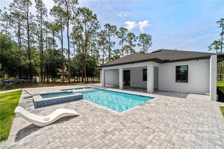 View of pool with a patio area and a pool with connected hot tub