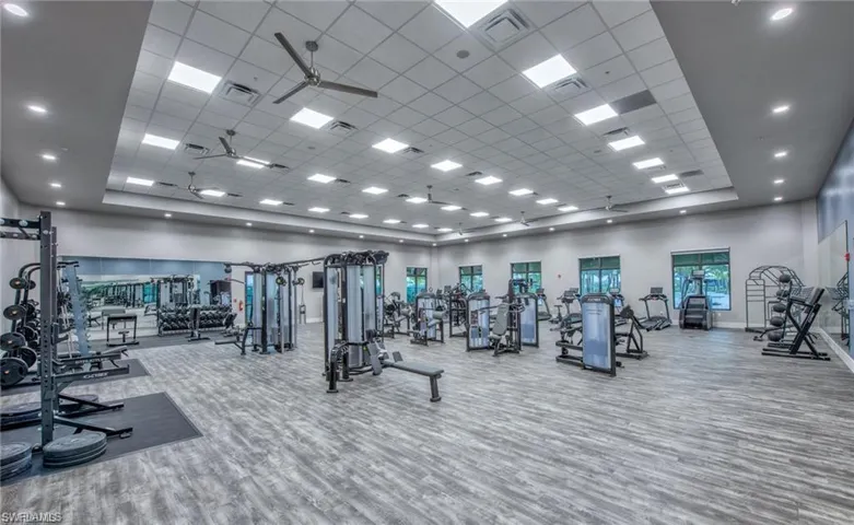 Workout area featuring a ceiling fan, a towering ceiling, and a paneled ceiling