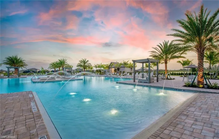 Pool at dusk featuring a community pool and a patio