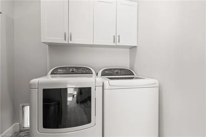 Well-appointed laundry room with cabinetry and space for all your essentials.