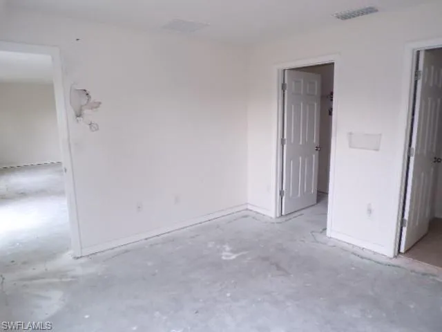 Unfurnished bedroom featuring unfinished concrete floors and baseboards