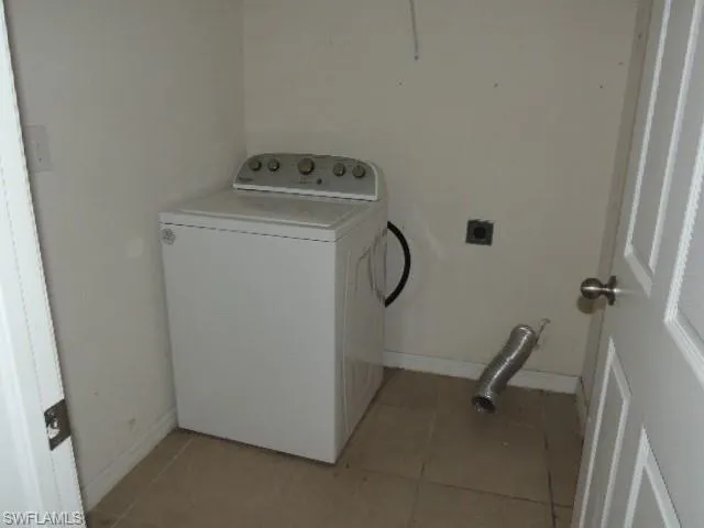 Laundry room with washer / clothes dryer and light tile patterned floors