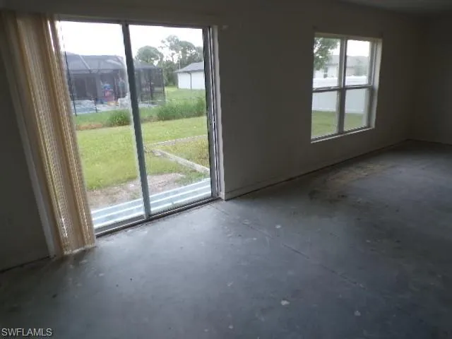 Unfurnished living room with unfinished concrete floors and baseboards