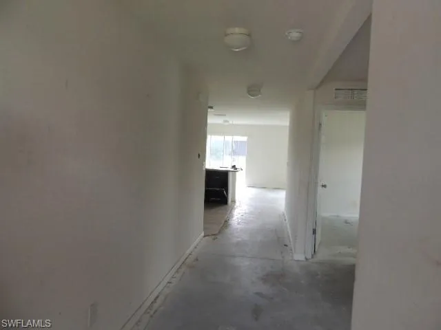 Hallway with unfinished concrete flooring
