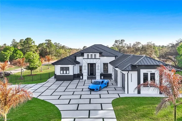 Rear view of house with a standing seam roof and stucco siding
