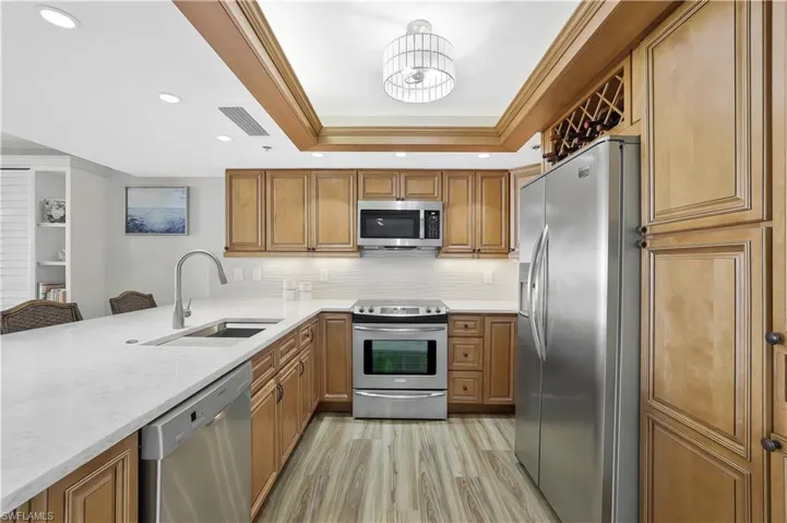 Quart Counters and custom backsplash highlight spacious kitchen