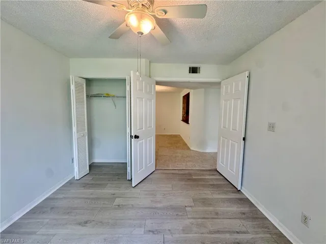 Wood-finish flooring throughout, complemented by a ceiling fan with integrated lighting