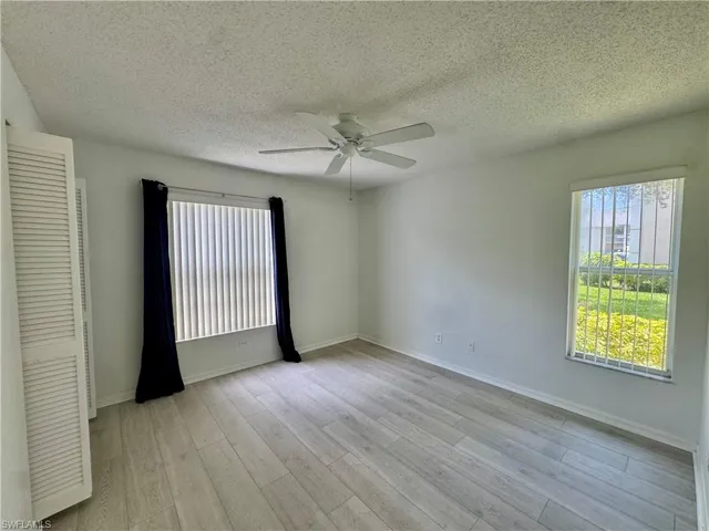Bright room featuring wood-finish flooring and a ceiling fan