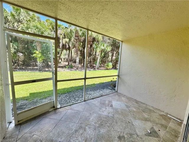 Screened lanai featuring diagonal-set tile flooring and textured walls and ceiling