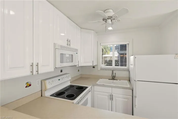 Kitchen with appliances, cabinets and breakfast bar