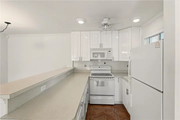 Kitchen with appliances, cabinets and breakfast bar