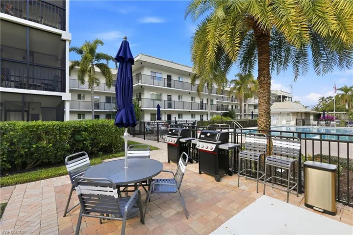 View of pool patio featuring an area for grilling and outdoor dining