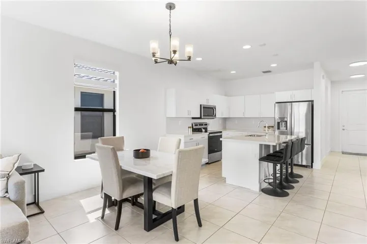 Dining room with light tile patterned floors and a chandelier