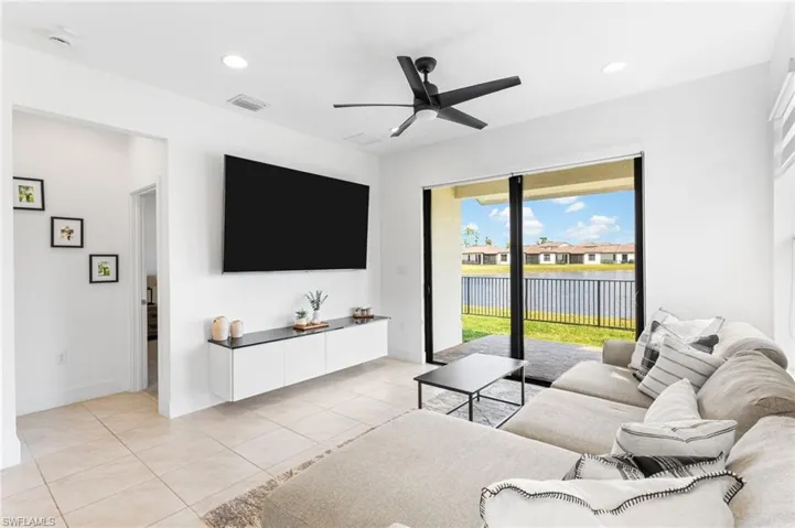 Living area with ceiling fan, light tile patterned floors, and recessed lighting