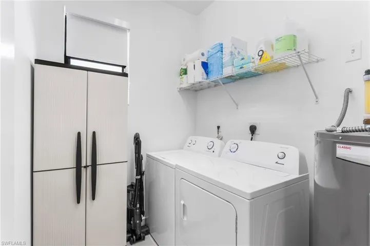 Laundry room featuring water heater and independent washer and dryer