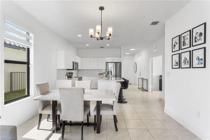 Dining space featuring hanging lights and light tile patterned floors