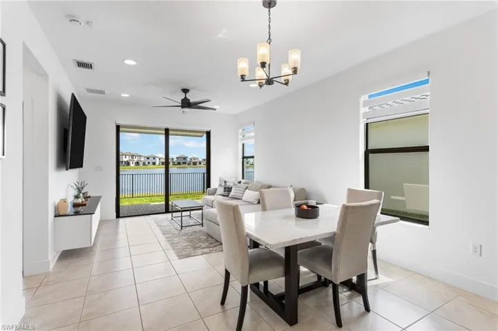 Dining space featuring hanging lights, a ceiling fan, and light tile patterned floors