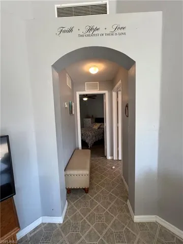 Hall with arched walkways and baseboards