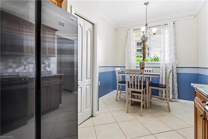 Dining space featuring light tile patterned floors, crown molding, and a chandelier