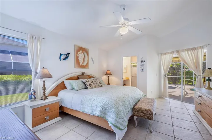Bedroom featuring access to exterior, ensuite bathroom, a ceiling fan, and lofted ceiling