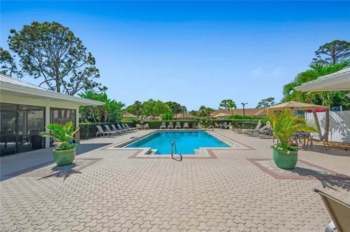Community pool with a patio area and fence
