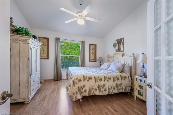Bedroom featuring lofted ceiling, wood finished floors, and a ceiling fan