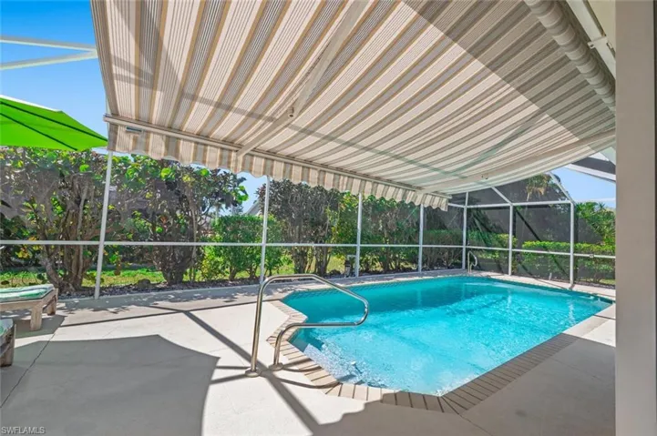 Outdoor pool featuring glass enclosure and a patio area
