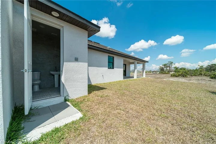 View of green lawn featuring a patio and a sink