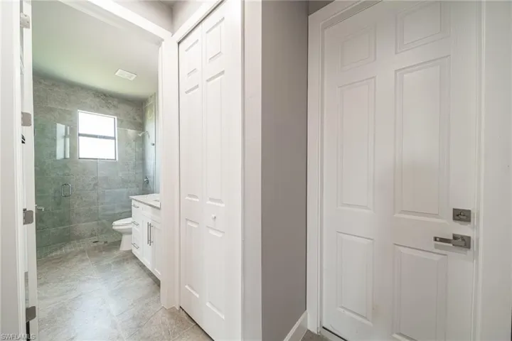 Bathroom with vanity, a stall shower, a closet, and light tile patterned flooring