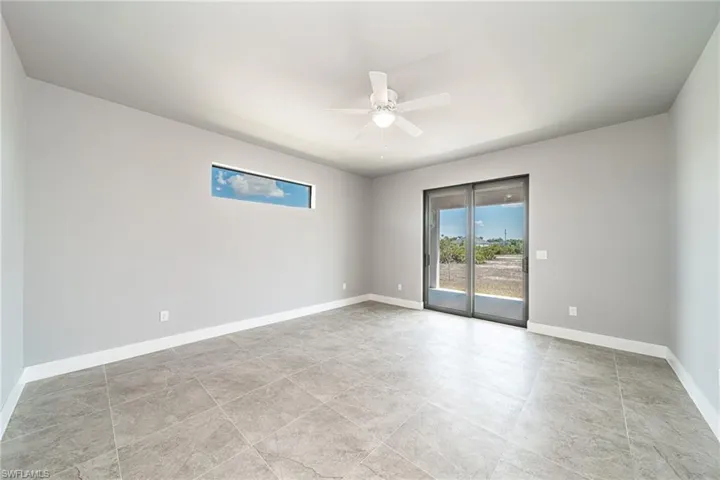 Unfurnished room featuring a ceiling fan and baseboards
