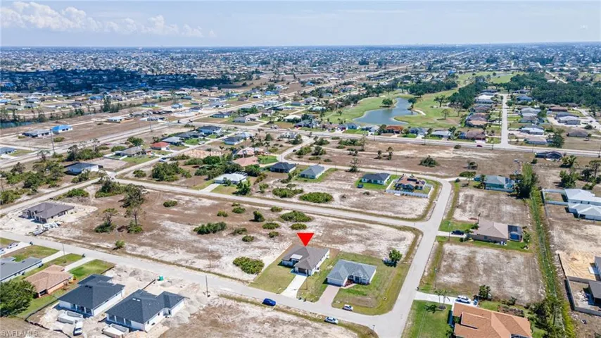 Aerial view of property and surrounding area featuring nearby suburban area