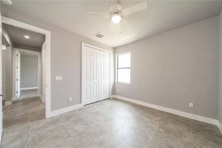 Unfurnished bedroom featuring ceiling fan and a closet