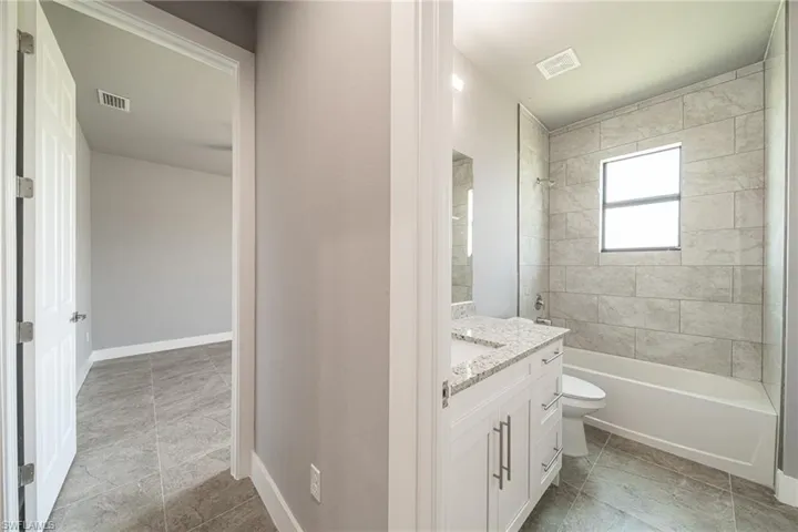 Full bathroom featuring bathing tub / shower combination, vanity, and light tile patterned floors