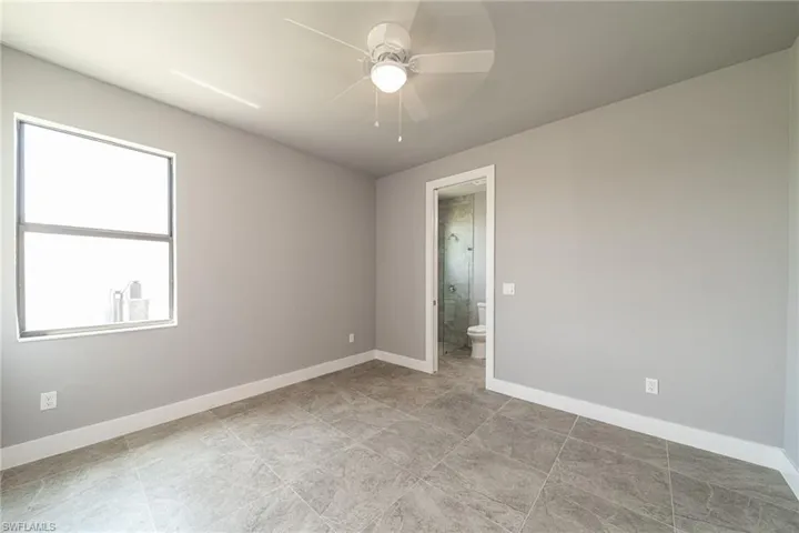 Empty room with baseboards and a ceiling fan