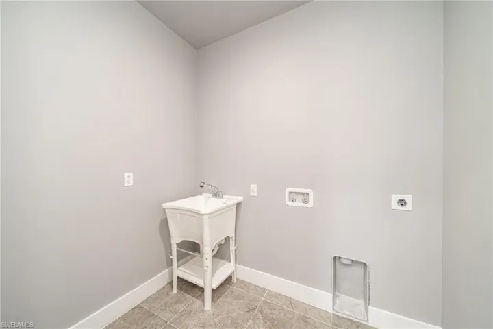 Laundry room featuring washer hookup, hookup for an electric dryer, and light tile patterned flooring