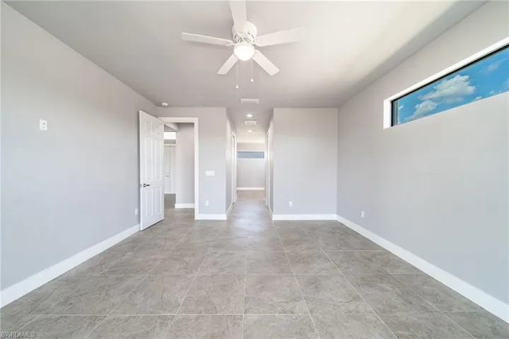 Unfurnished bedroom with a walk in closet and ceiling fan