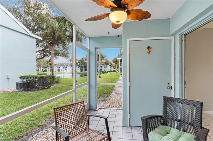 screened patio featuring a ceiling fan and a water view