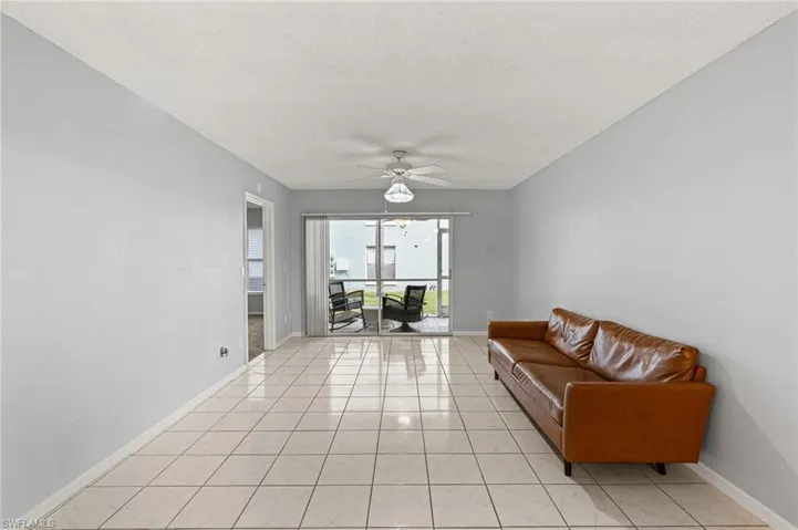 Tiled living area featuring a textured ceiling and a ceiling fan