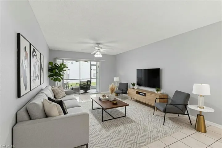 Living room virtual staged featuring light tile patterned flooring, a ceiling fan, and a textured ceiling