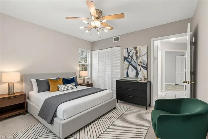 Bedroom virtual staged featuring light carpet, a closet, and a ceiling fan