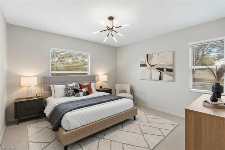 Bedroom virtual staged with light carpet and suspended lighting