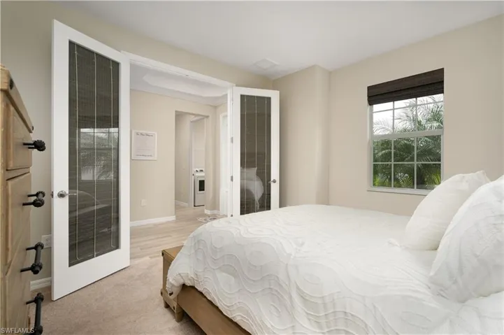 Bedroom with light colored carpet and french doors