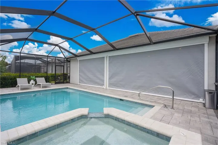 View of pool with an in ground hot tub, a patio, and a lanai