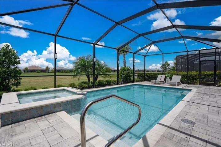 View of swimming pool featuring a patio, an in ground hot tub, and glass enclosure
