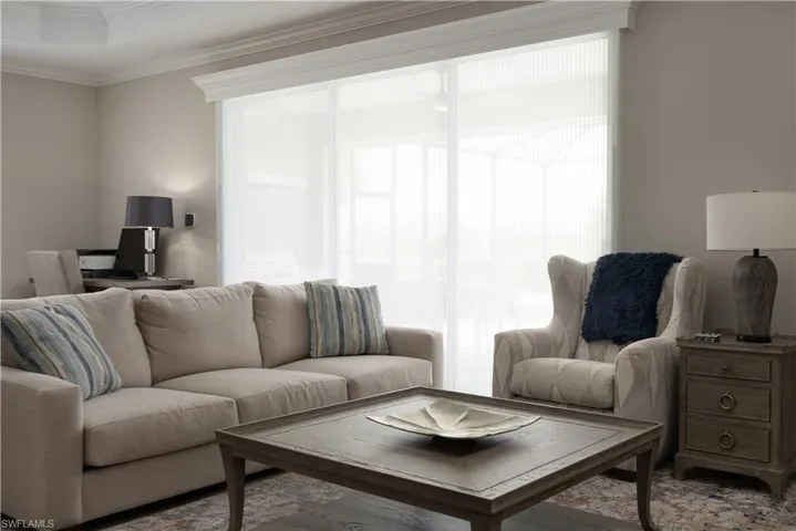 Living room featuring crown molding, a wealth of natural light, and a tray ceiling