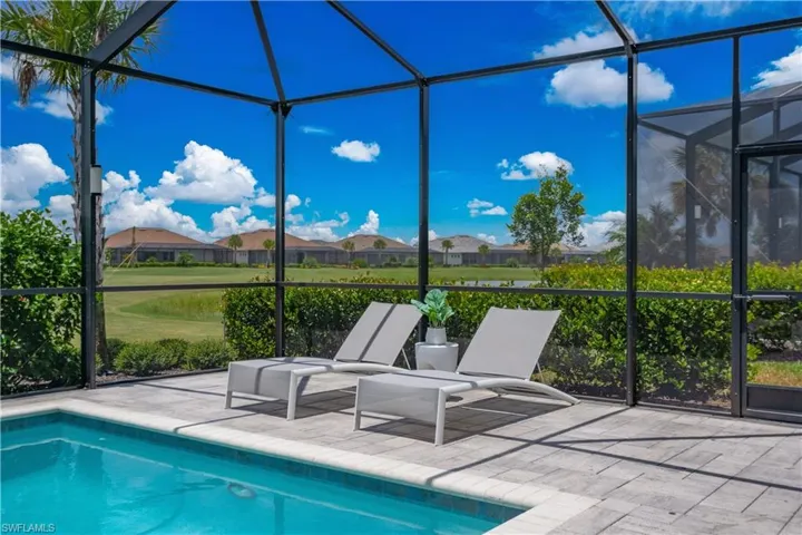 View of pool featuring a patio area and glass enclosure