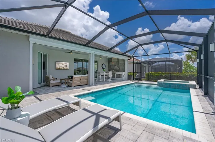 View of swimming pool featuring an in ground hot tub, a patio, glass enclosure, and outdoor lounge area